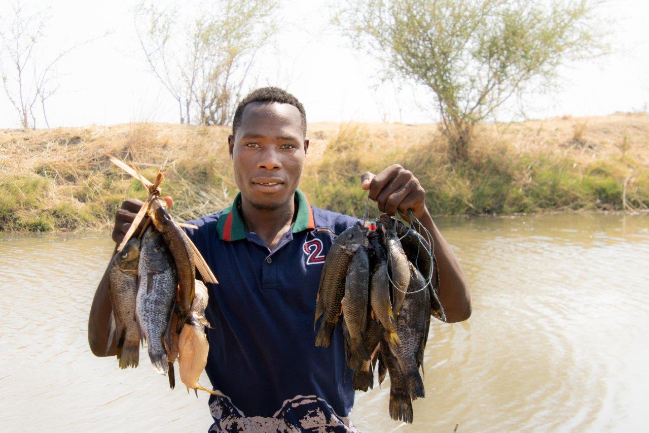 afrikaanse man houd vissen in lucht